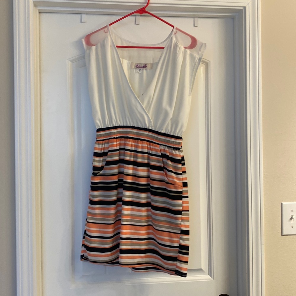 White top with clasp and striped bottom dress.